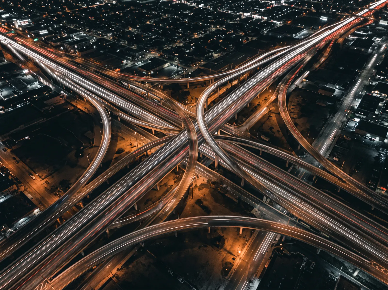 A highway interchange at night, traffic drawn out in long exposure